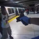 A BART police officer holds Michael Smith at gunpoint during an arrest at the Embarcadero station. Body camera still.